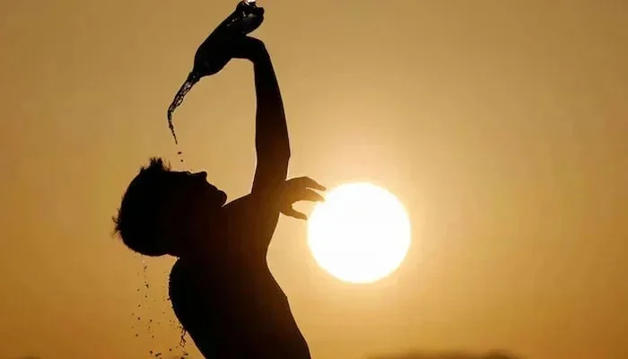 Man drinking water under shade during severe heatwave in Pakistan – heat safety tips